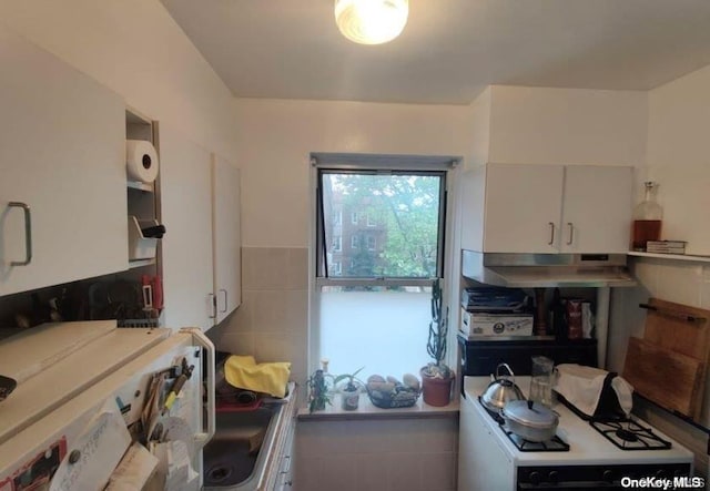 kitchen featuring white cabinetry and white gas stove