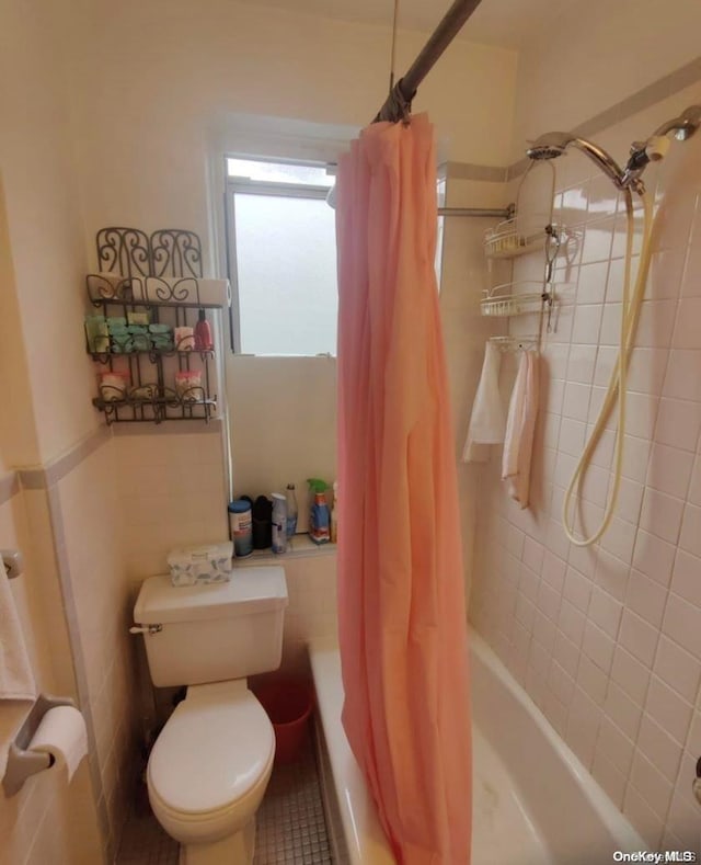 bathroom featuring toilet, tile patterned floors, shower / tub combo with curtain, and tile walls