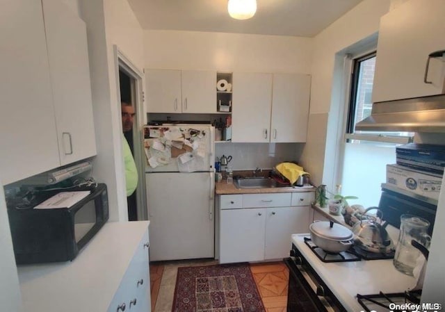 kitchen featuring tasteful backsplash, sink, white cabinets, and white appliances