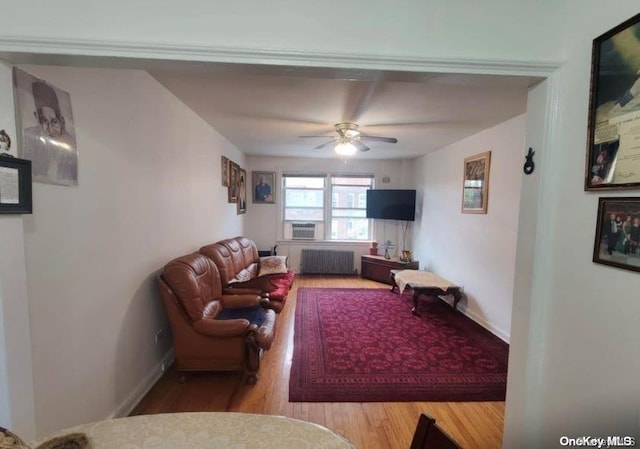 living room featuring ceiling fan, light wood-type flooring, and radiator heating unit