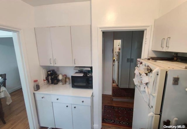 kitchen with white fridge, white cabinetry, and hardwood / wood-style flooring