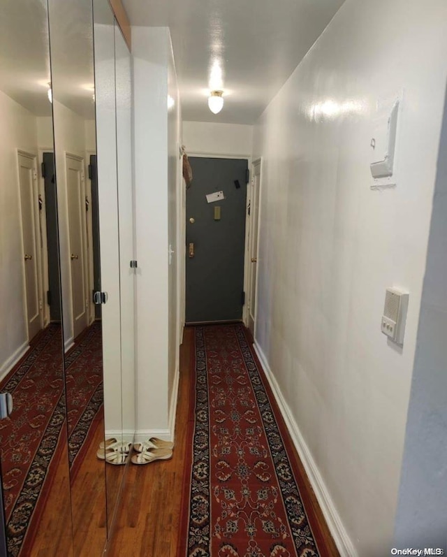 corridor with dark hardwood / wood-style flooring