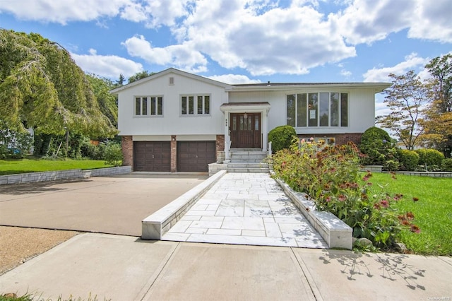 split foyer home featuring a garage and a front yard