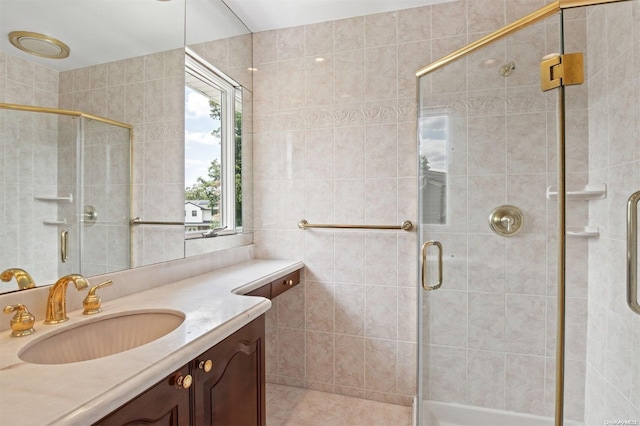 bathroom with tile walls, vanity, and an enclosed shower