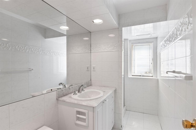 bathroom featuring vanity and tile walls