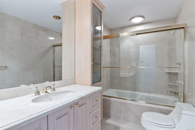 full bathroom with tile patterned floors, vanity, toilet, and shower / bath combination with glass door