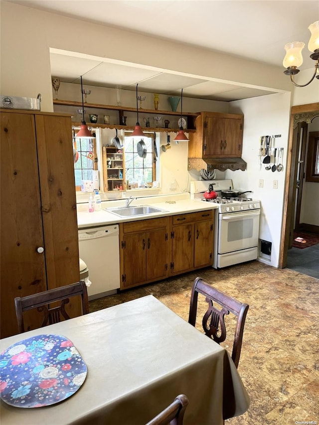 kitchen with white appliances, sink, hanging light fixtures, and a chandelier