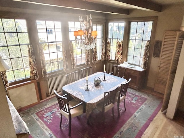 dining area featuring beam ceiling, wood-type flooring, and a chandelier