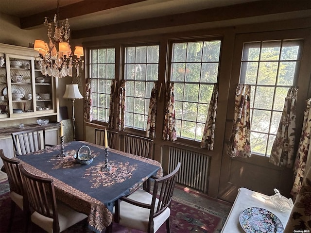 dining area with beamed ceiling, plenty of natural light, and an inviting chandelier