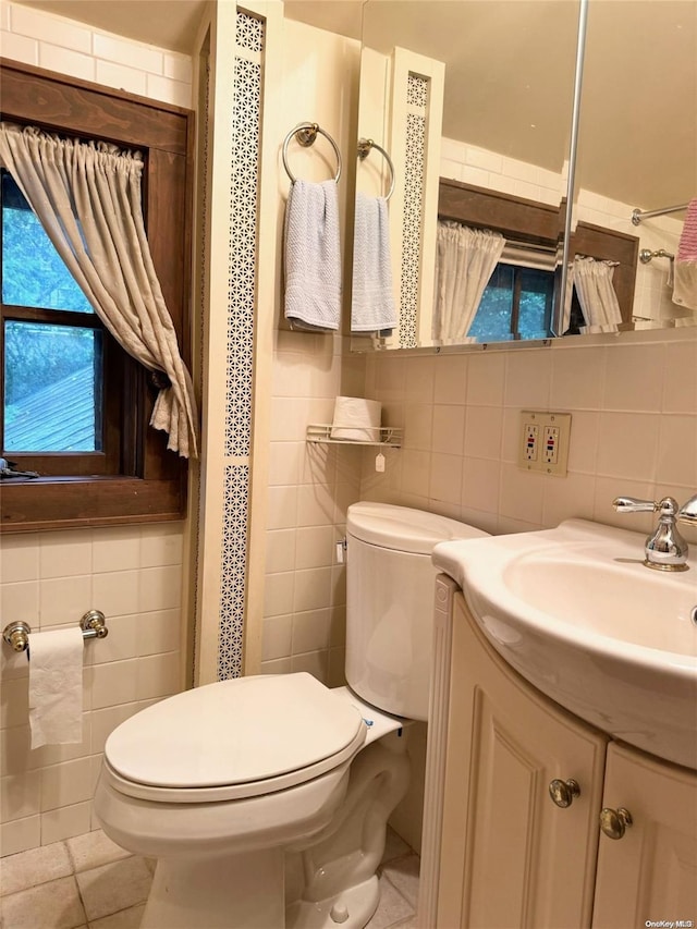 bathroom with tile patterned floors, tile walls, and toilet