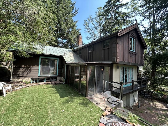 329 Forest Rd, Little Neck, NY 11363 - rear view of property featuring board and batten siding, a chimney, a standing seam roof, and a yard