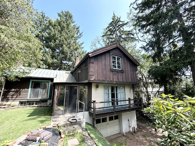 view of front of house with a sunroom, a garage, and a front lawn