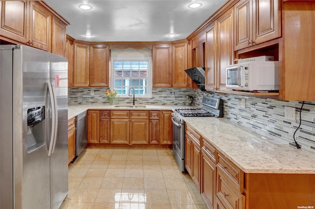 kitchen featuring light stone counters, sink, stainless steel appliances, and tasteful backsplash