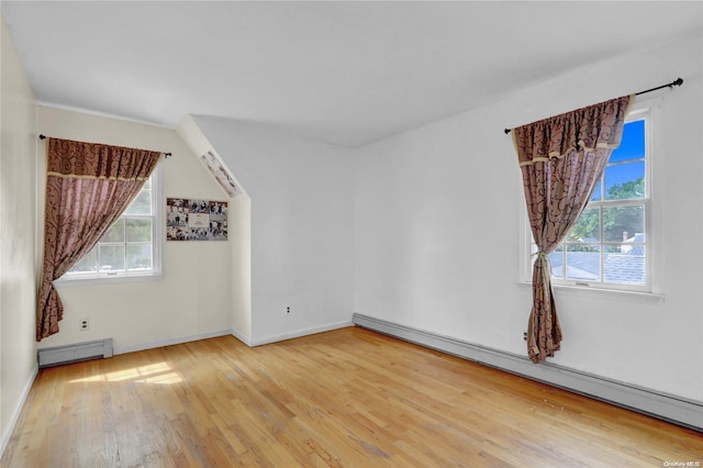 bonus room with a healthy amount of sunlight, a baseboard radiator, and light hardwood / wood-style floors