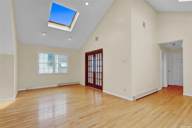 spare room with light wood-type flooring, high vaulted ceiling, and a baseboard heating unit