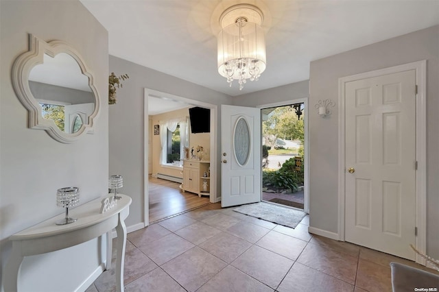 tiled entryway featuring baseboard heating, plenty of natural light, and an inviting chandelier