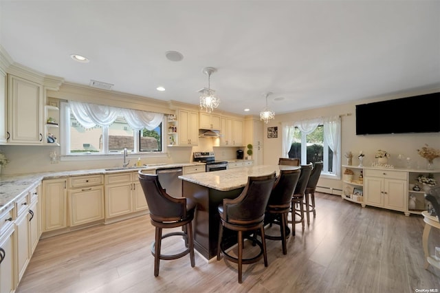 kitchen featuring a kitchen breakfast bar, stainless steel appliances, a kitchen island, and plenty of natural light