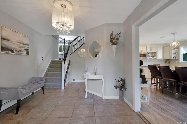 foyer entrance featuring light hardwood / wood-style flooring, a healthy amount of sunlight, and a notable chandelier