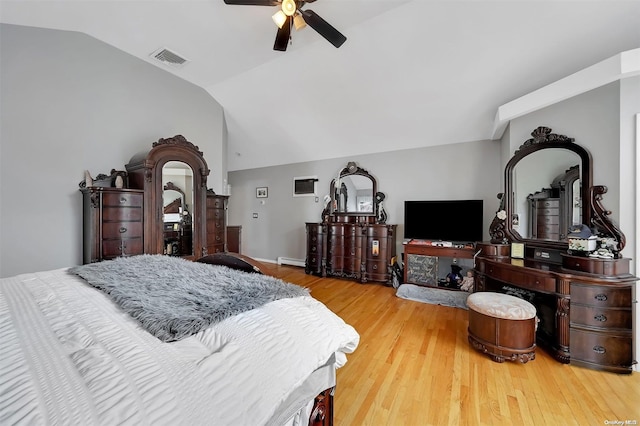 bedroom featuring baseboard heating, ceiling fan, wood-type flooring, and vaulted ceiling