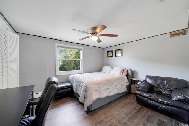 bedroom featuring ceiling fan, dark hardwood / wood-style floors, baseboard heating, and a closet