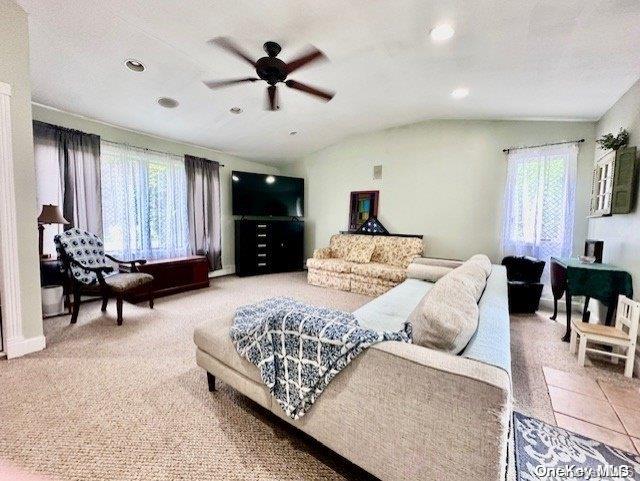 carpeted living room featuring ceiling fan and lofted ceiling