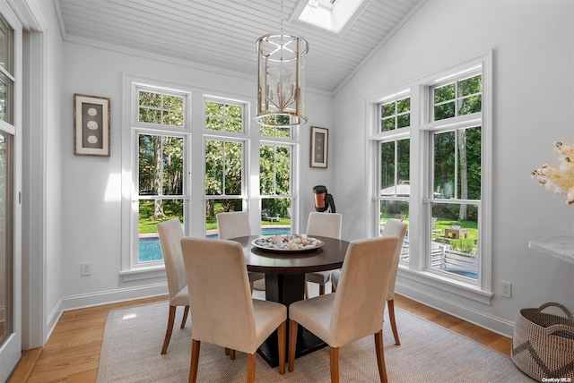 dining space featuring vaulted ceiling, light wood-type flooring, ornamental molding, a notable chandelier, and wood ceiling