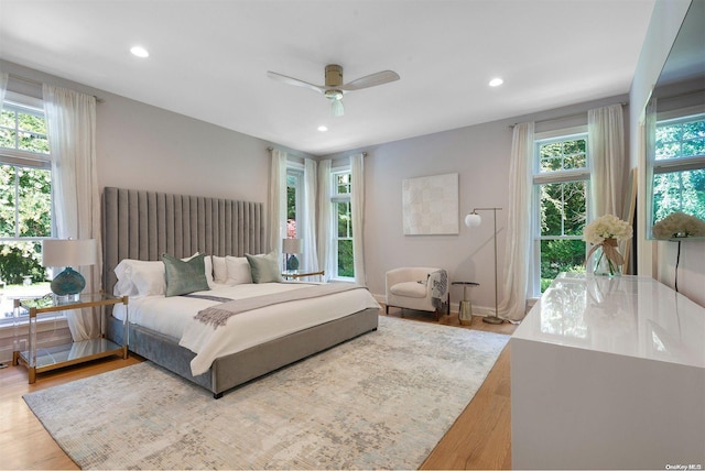 bedroom with light hardwood / wood-style flooring, multiple windows, and ceiling fan