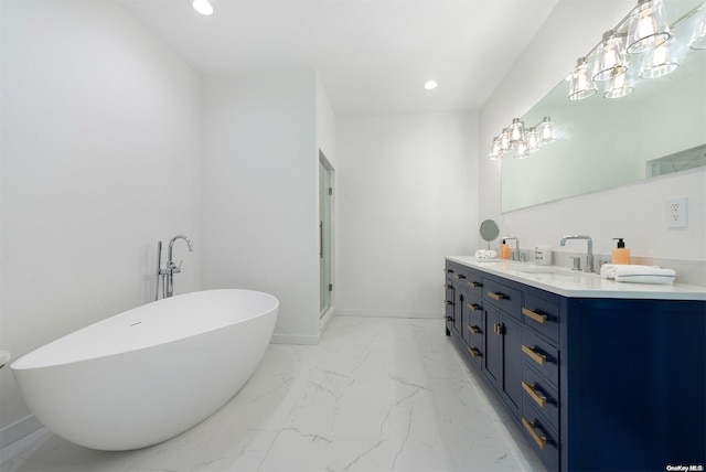 bathroom with a tub, vanity, and a chandelier