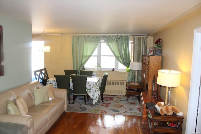 living room with an inviting chandelier, radiator heating unit, and hardwood / wood-style flooring