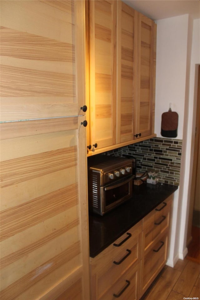 kitchen with tasteful backsplash, hardwood / wood-style floors, and light brown cabinetry