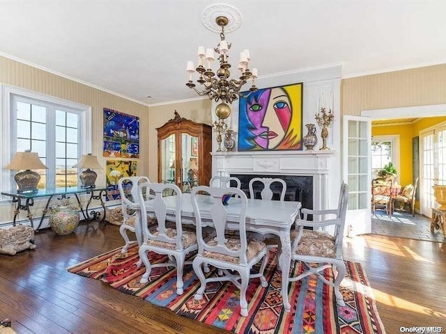 dining room with wood-type flooring, an inviting chandelier, a baseboard heating unit, and crown molding