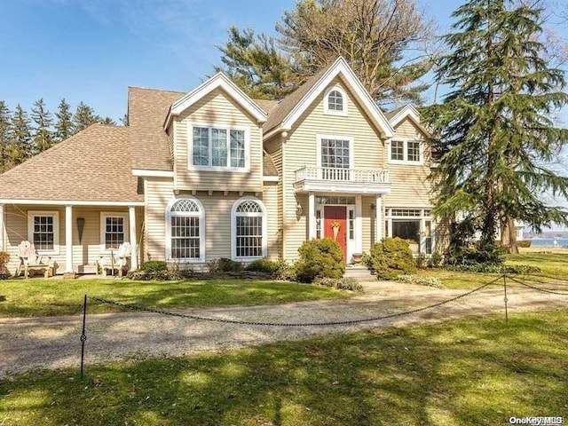 view of front of property with a balcony and a front lawn