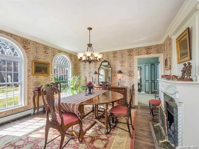 dining space featuring hardwood / wood-style flooring, baseboard heating, crown molding, and a chandelier