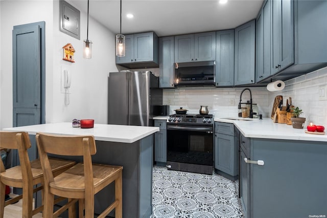 kitchen with decorative backsplash, a breakfast bar, stainless steel appliances, sink, and hanging light fixtures