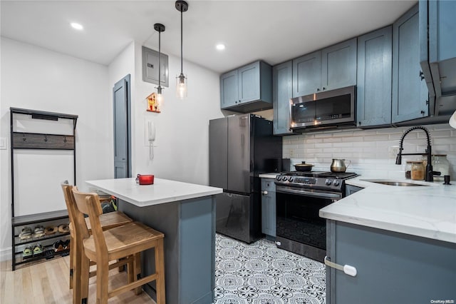 kitchen featuring black refrigerator, light stone counters, sink, electric range, and decorative light fixtures