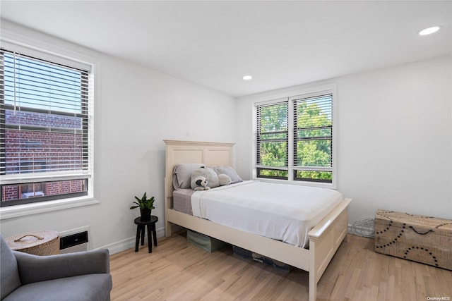 bedroom with multiple windows and light hardwood / wood-style flooring