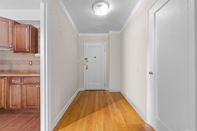 hall with ornamental molding and light wood-type flooring