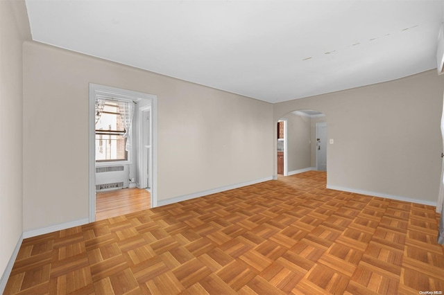 empty room featuring radiator heating unit and light parquet flooring