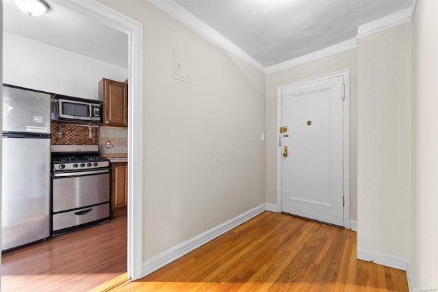 entrance foyer with crown molding and hardwood / wood-style floors