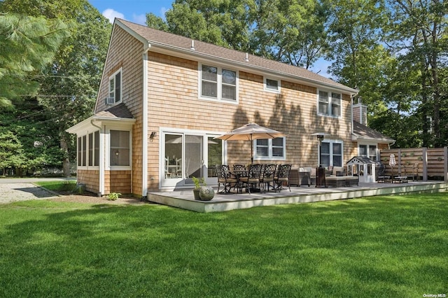 back of house featuring a patio, a lawn, and a sunroom