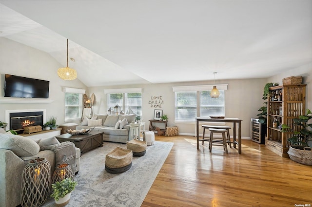 living room with light hardwood / wood-style flooring and vaulted ceiling