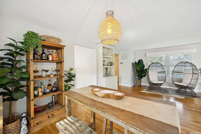 dining area with bar area and hardwood / wood-style flooring