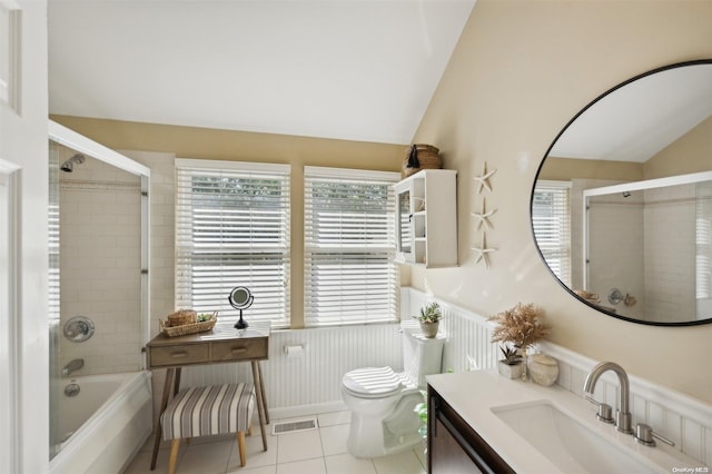 full bathroom with tile patterned flooring, tiled shower / bath, vaulted ceiling, and toilet