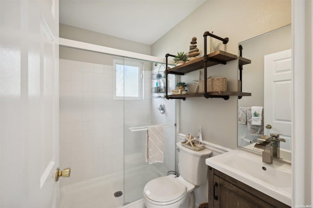 bathroom featuring vanity, a shower with shower door, and toilet