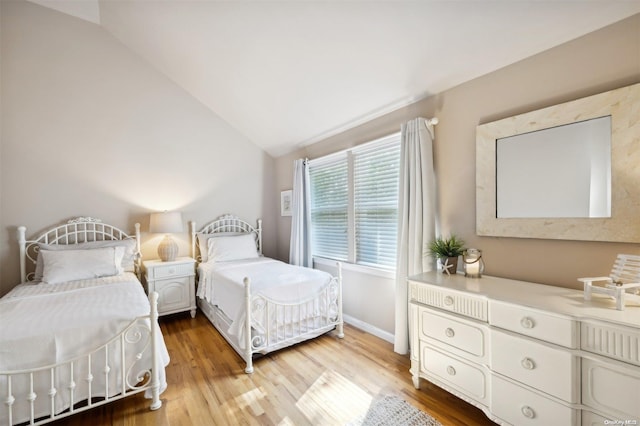 bedroom with light hardwood / wood-style floors and vaulted ceiling