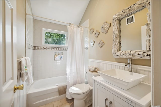 full bathroom with shower / bath combo, vanity, tile patterned floors, vaulted ceiling, and toilet