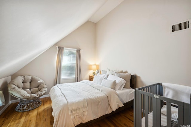 bedroom featuring dark wood-type flooring and vaulted ceiling