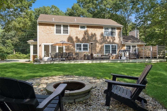 back of house with a lawn, an outdoor fire pit, and a patio