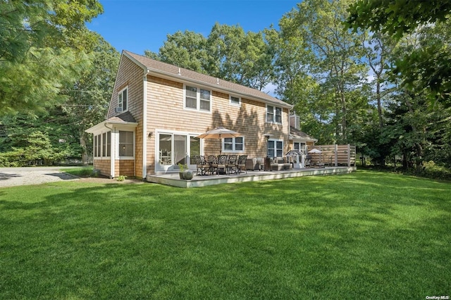 back of property featuring a lawn and a sunroom