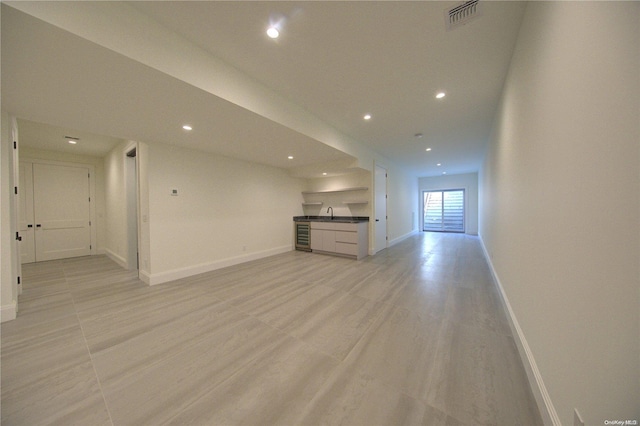 151 Newtown Ln, East Hampton, NY 11937 - unfurnished living room featuring recessed lighting, baseboards, wet bar, light wood-style flooring, and wine cooler